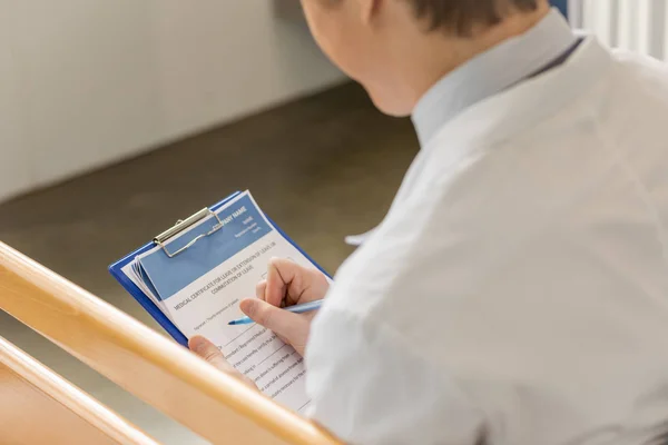 Doctor writing diagnosis — Stock Photo