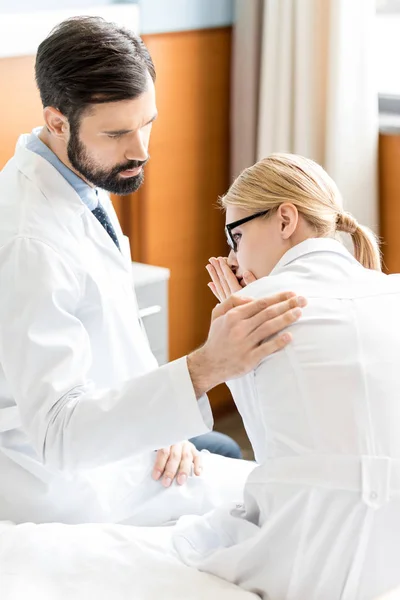 Doctor soothing upset colleague — Stock Photo