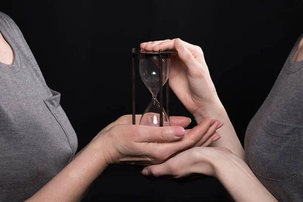 Woman giving hourglass to daughter — Stock Photo