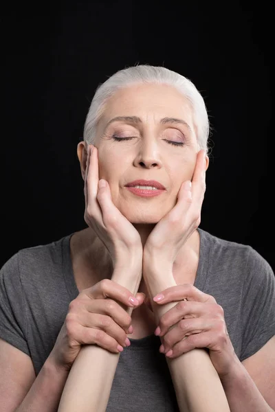 Mains de fille touchant mère visage — Photo de stock