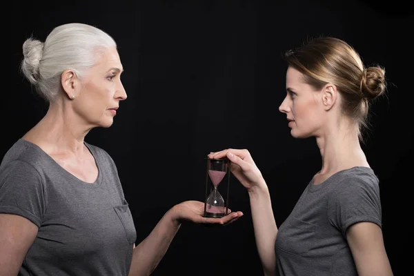 Senior woman giving hourglass to daughter — Stock Photo