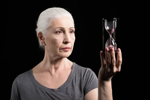 Старша жінка тримає піщаний годинник — стокове фото