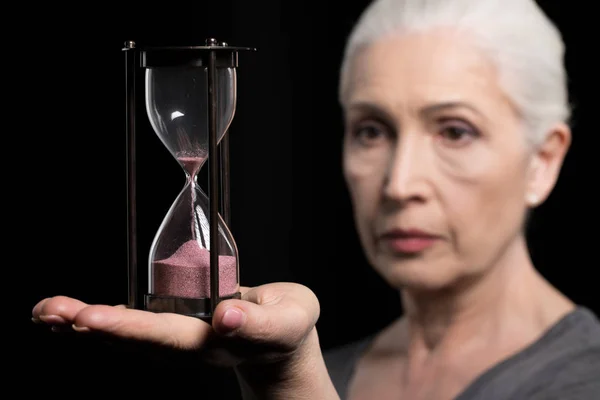 Donna anziana in possesso di orologio sabbia — Foto stock