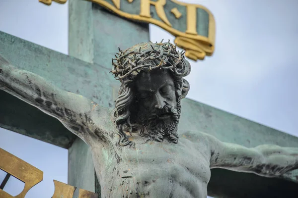 Jesus Cristo escultura no crucifixo cruz no fundo do céu dramático — Fotografia de Stock