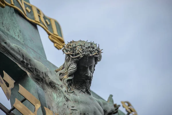 Jesus Christ sculpture on the cross crucifix on dramatic sky background — Stock Photo, Image