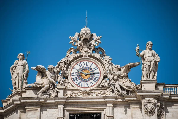 Madernos fasad med skulpturer, bell och klockan mot himmel bakgrund. Peterskyrkan. Vatikanen, Rom, Italien — Stockfoto