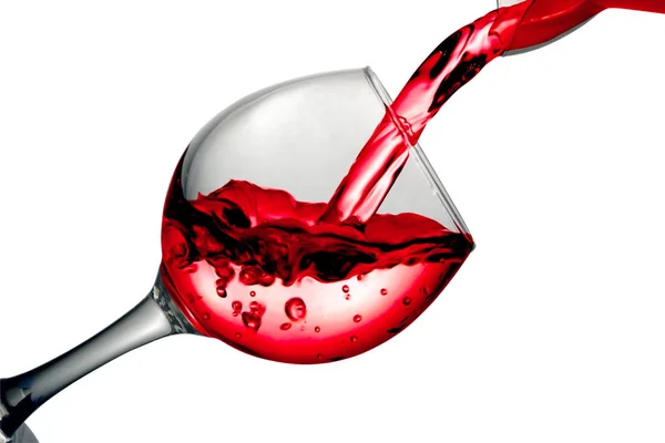 Red dry wine pours into a wineglass on a white background — Stock Photo, Image