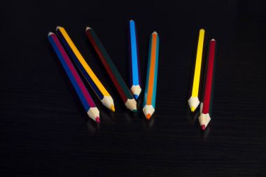 Koyu ahşap arka plan üzerinde renkli kalemler