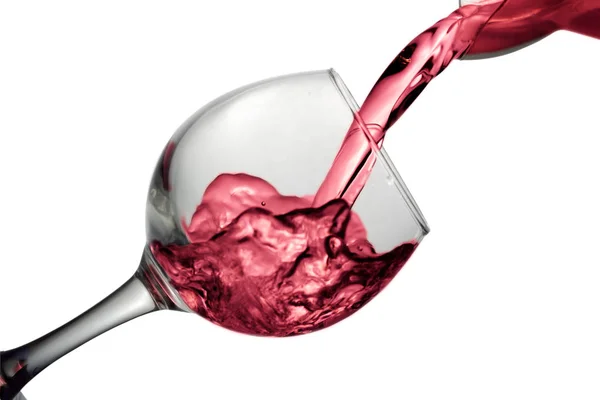 Red dry wine pours into a wineglass on a white background — Stock Photo, Image