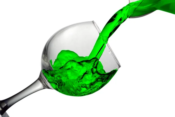Grönt vatten rinner i ett glas på en vit bakgrund — Stockfoto