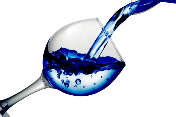 Lila vatten rinner i ett glas på en vit bakgrund — Stockfoto