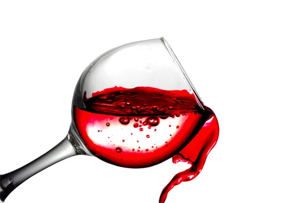 Vino tinto seco vierte en una copa de vino sobre un fondo blanco —  Fotos de Stock