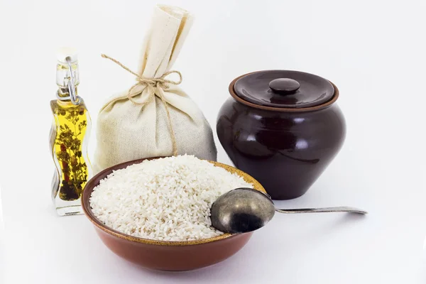 A composição de grumos de arroz em um pial de barro ao lado de um pote de barro e uma colher de cobre , — Fotografia de Stock