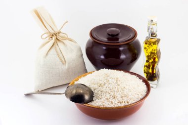 Pirinç kabuğu çıkarılmış tane bir kil toprak kap ve bakır kaşıkla yanındaki pial bileşimi,