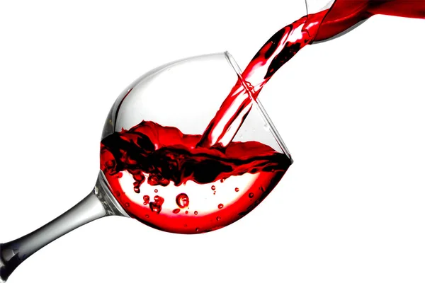 Red dry wine pours into a wineglass on a white background — Stock Photo, Image