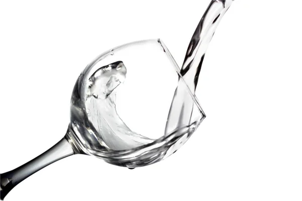 Χύνει νερό στο ποτήρι σε λευκό φόντο, μονόχρωμη εικόνα — Φωτογραφία Αρχείου