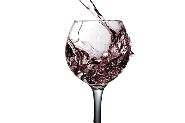 Red dry wine pours into a wineglass on a white background — Stock Photo, Image