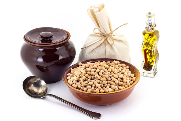 The composition of chick peas in a clay pial next to a clay pot and a copper spoon, Stock Photo