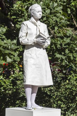 29.06.2017, Saint Petersburg, Rusya Federasyonu. Beyaz renkli bir kitap ile bir anıt kadın tasvir MIME boyalı