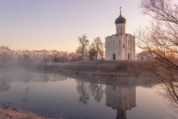 Вид на храм Покрова Пресвятой Богородицы на реке Ил при солнечном свете
.
