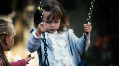 İki kız parkta sallanan