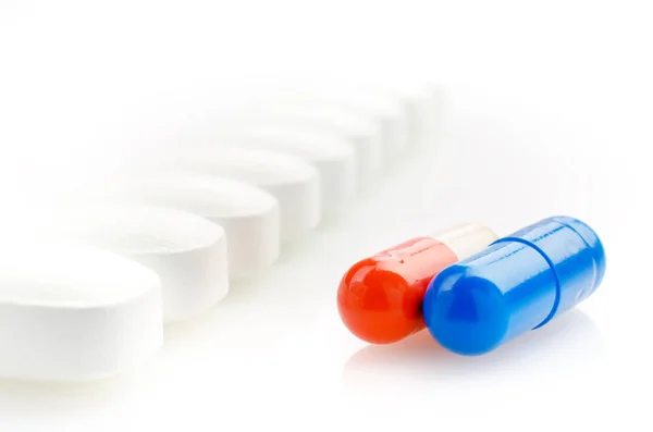 Red, Blue Capsules and White Pills — Stock Photo, Image