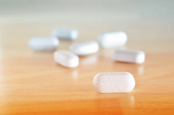 Witte pillen op tafel — Stockfoto