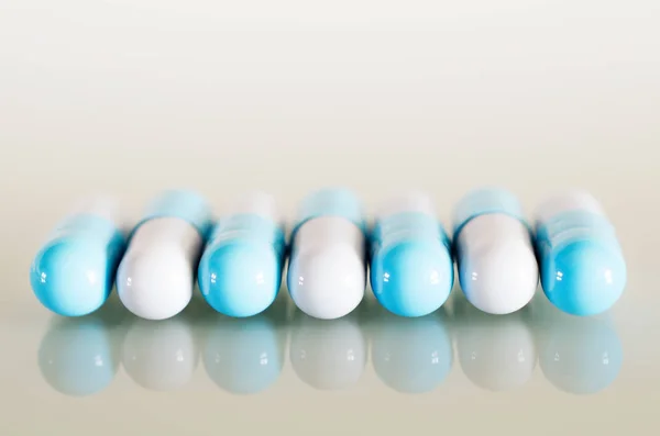 Синие и белые медицинские капсулы — стоковое фото