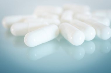 Ayna yüzeyinde beyaz tıbbi kapsül