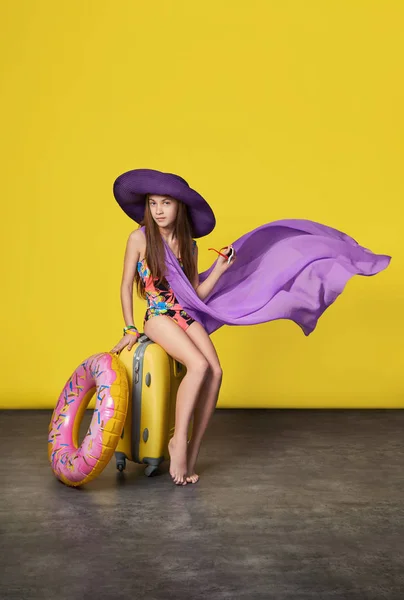 Dziewczynę w strój kąpielowy w kapeluszu z walizką — Zdjęcie stockowe