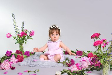 Güzel bebek bir buket çiçek ile oturma