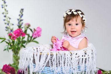 bir çiçek ile güzel küçük bir çocuk oturur.