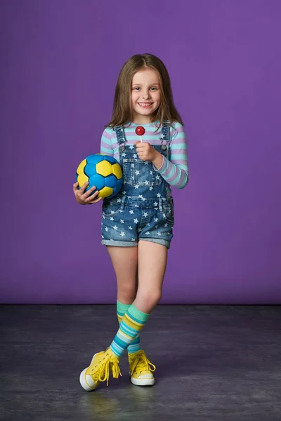 Hermosa niña comiendo dulces. moda deportiva para niños . —  Fotos de Stock