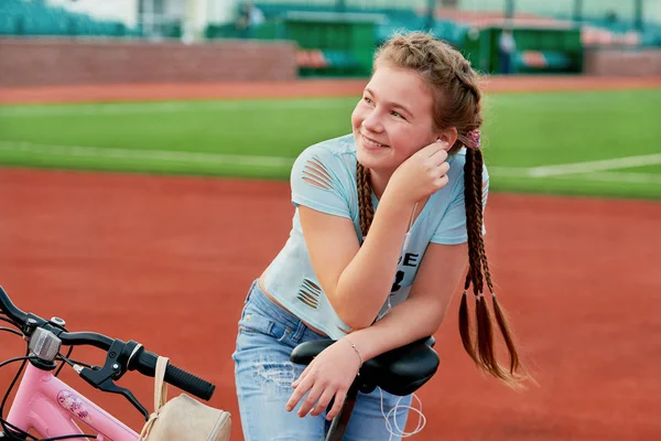 Dospívající dívka relaxační na stadionu. Dívka na dovolené na kole volno — Stock fotografie