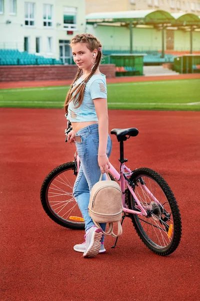 Dospívající dívka na dovolené na stadium.a dítě pózuje s kolo. — Stock fotografie