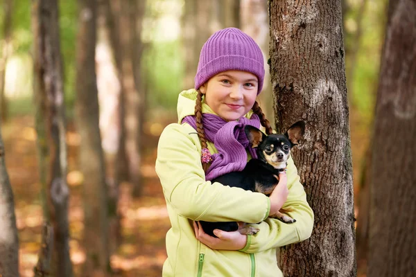 女孩在户外戴帽子, 带着一只小狗. 微笑的十几岁女孩放松与狗. — 图库照片