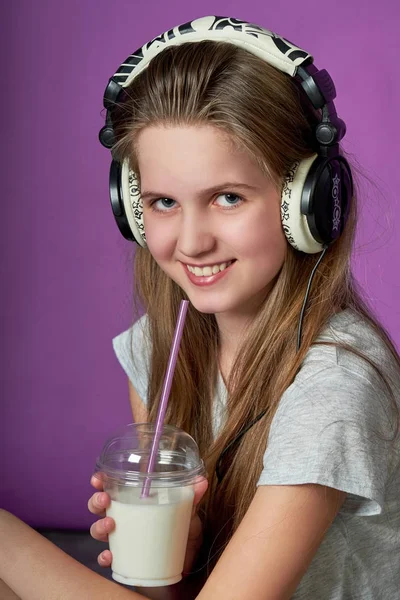 Teen κορίτσι αγαπά να ακούτε το τραγούδι με headphones.girl ροφήματα smoothies — Φωτογραφία Αρχείου