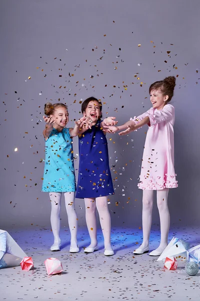 Feliz grupo de niños lanzando confetti.Fashion ropa para niños, modelos de niños posando en la foto . — Foto de Stock