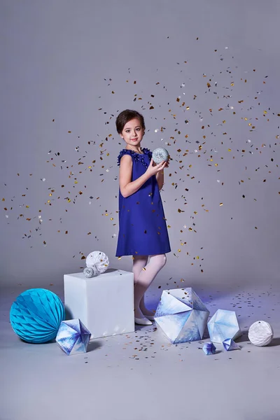 Une belle fille enfant avec des confettis dans la mode robe bleue. Adolescente de charme en studio, makeup.Happy vacances . — Photo