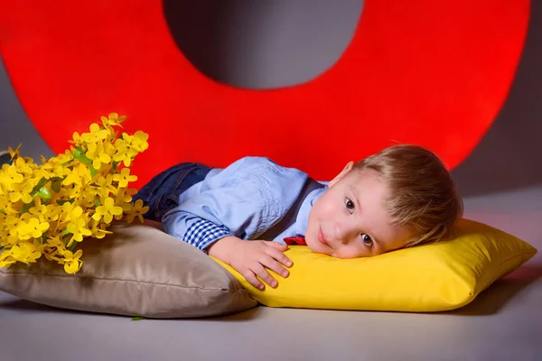 Roztomilé dítě studia leží na žluté polštář. Portrét krásné chlapeček Kavkazský. — Stock fotografie
