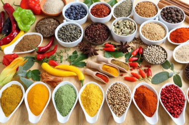 Ahşap bir zemin üzerinde seramik kaplar içinde Aromatik ve renkli baharatlar.