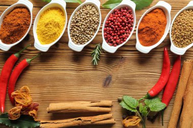 Ahşap arka plan üzerinde seramik kaplar içinde baharatlar. Yemek ve mutfak ingradients.