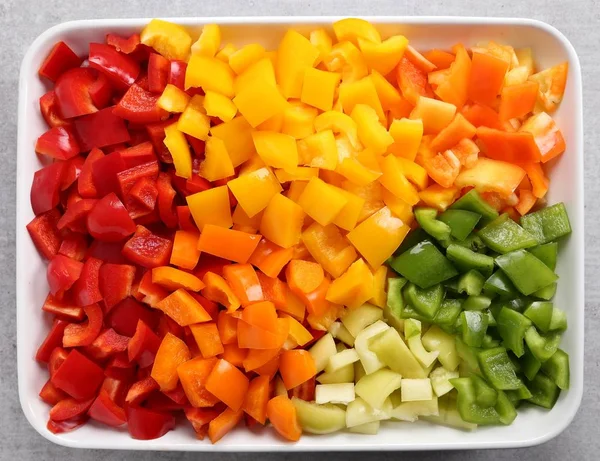 Bir seramik tabak içinde renkli, doğranmış biber.