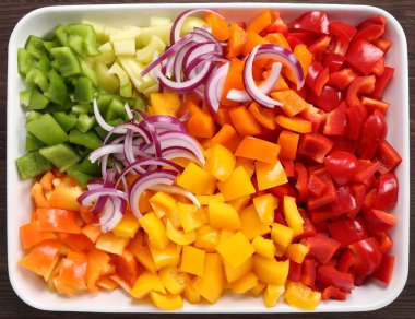 Bir seramik tabak içinde renkli, doğranmış biber.