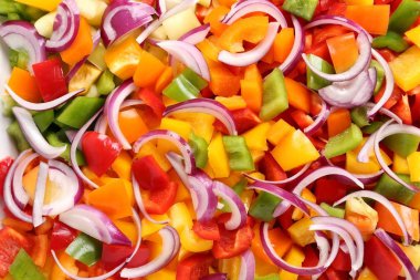 Bir seramik tabak içinde renkli, doğranmış biber.