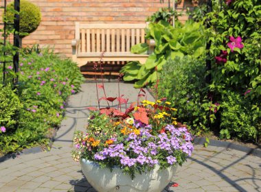 Bahçe süslemeleri. Seramik kapta çiçek aranjmanları. Dinlenme alanı.