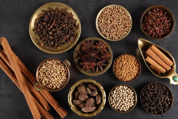 Esmer aromatik baharatlar metal kaselerde koyu bir arka planda. Üst görünüm.