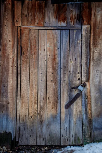 Porta in legno di un vecchio fienile con serratura in metallo — Foto Stock