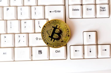 Cryptocurrency para bitcoin beyaz bir klavye üzerinde yatıyor