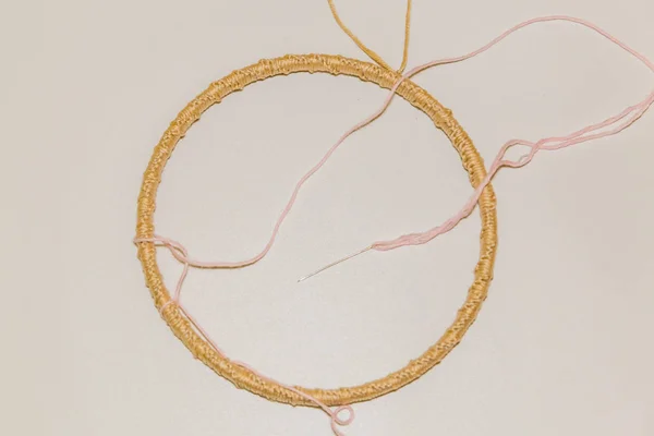 Women 's hands braid the hoop with threads — стоковое фото